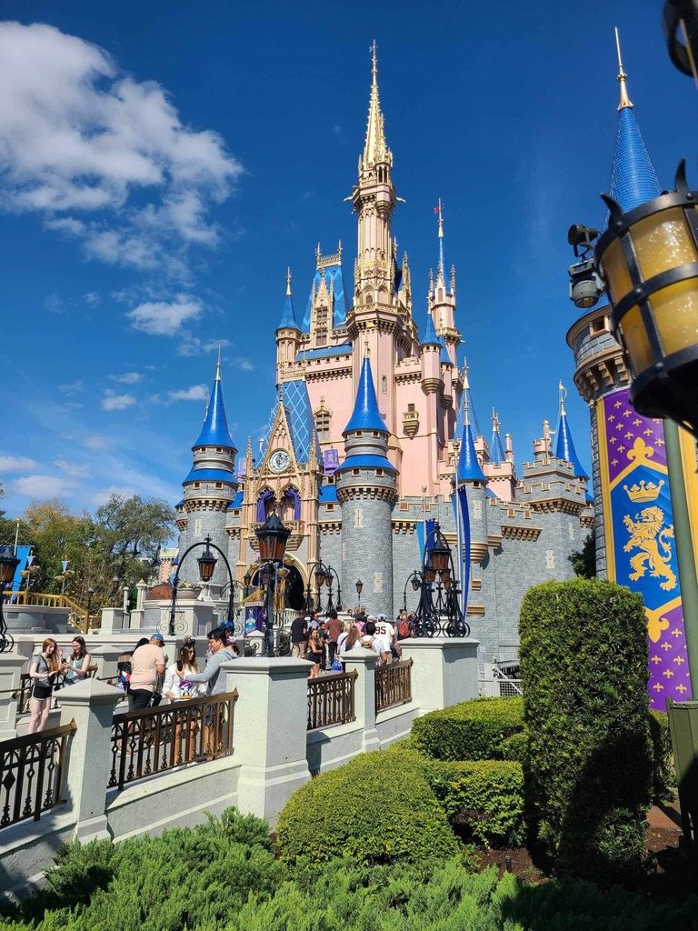 Side profile of the pink and blue Cinderella's Castle in Magic Kingdom with crowd