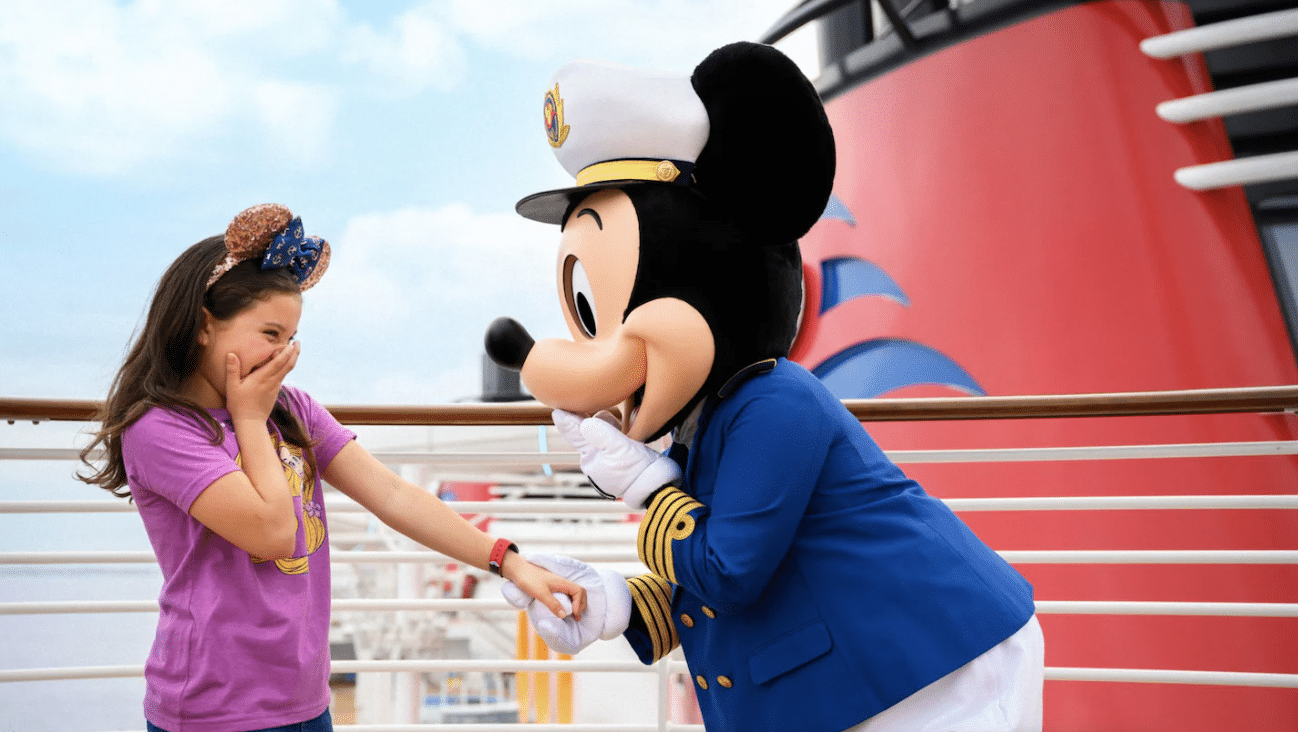 An image captured with the Photo Package of a young girl smiles in surprise while meeting Captain Mickey Mouse aboard a Disney cruise.