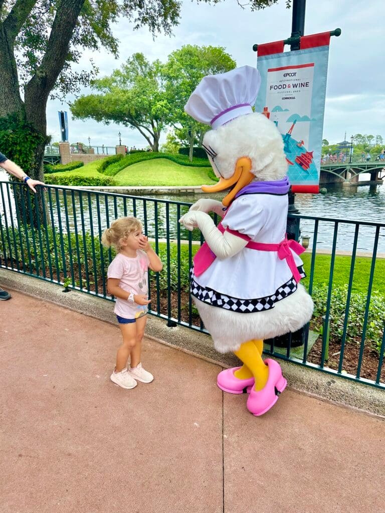 Little girl meets Daisy in her Food and Wine festival outfit at EPCOT World Showcase.