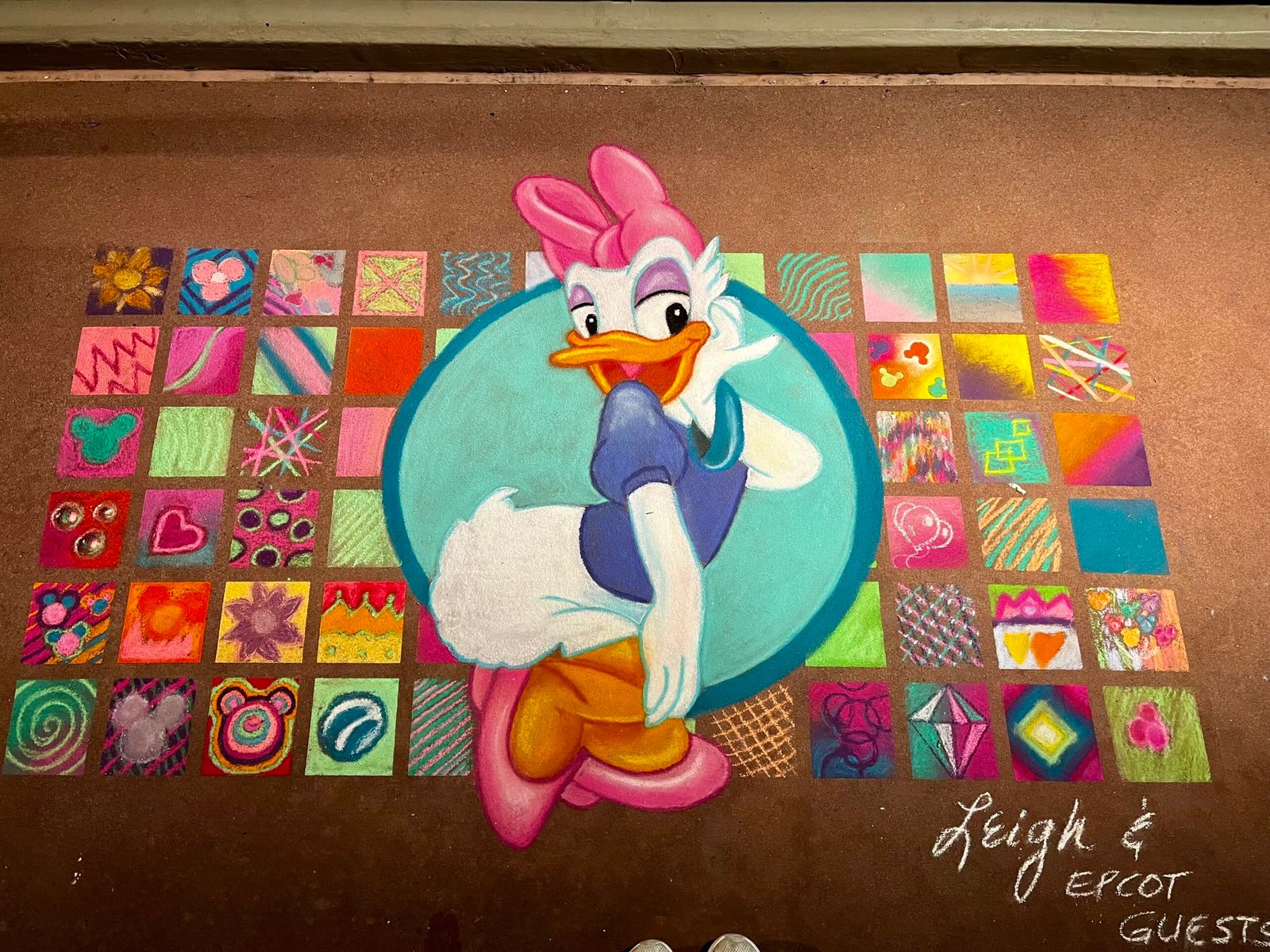 Image of a colorful Daisy Duck sidewalk chalk art made by an artist during EPCOT's International Festival of the Arts