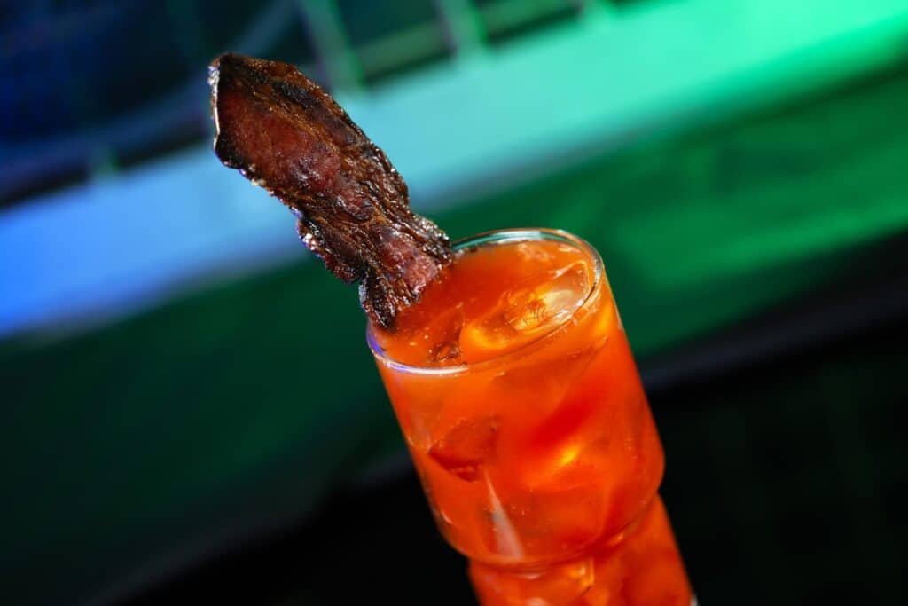 Disney's image of the Bloody Rancor with Candied Meat drink which consists of Titos' Handmade Vodka, Ancho Reyes Chile Liqeur, and house-made bloody mary mix garnished with a spicy candied rancor bacon.