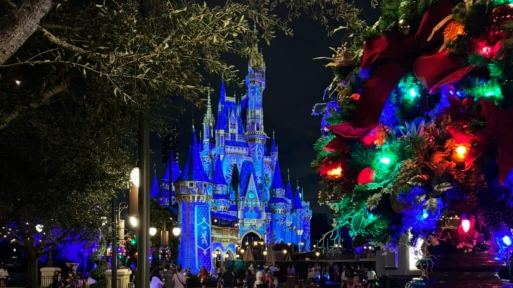 Cinderella's Castle at Mickey's Very Merry. Colored Christmas Lights and a blue projection on the castle.