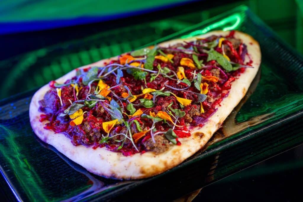 Disney's image of the Thruster Roasted Bantha Flatbread which is a naan flatbread with spiced chorizo beef and a four-cheese blend.