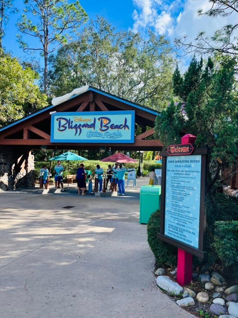 Entrance of Blizzard Beach Water Park at Walt Disney World with the welcome sign and hours of operation on a sunny day.