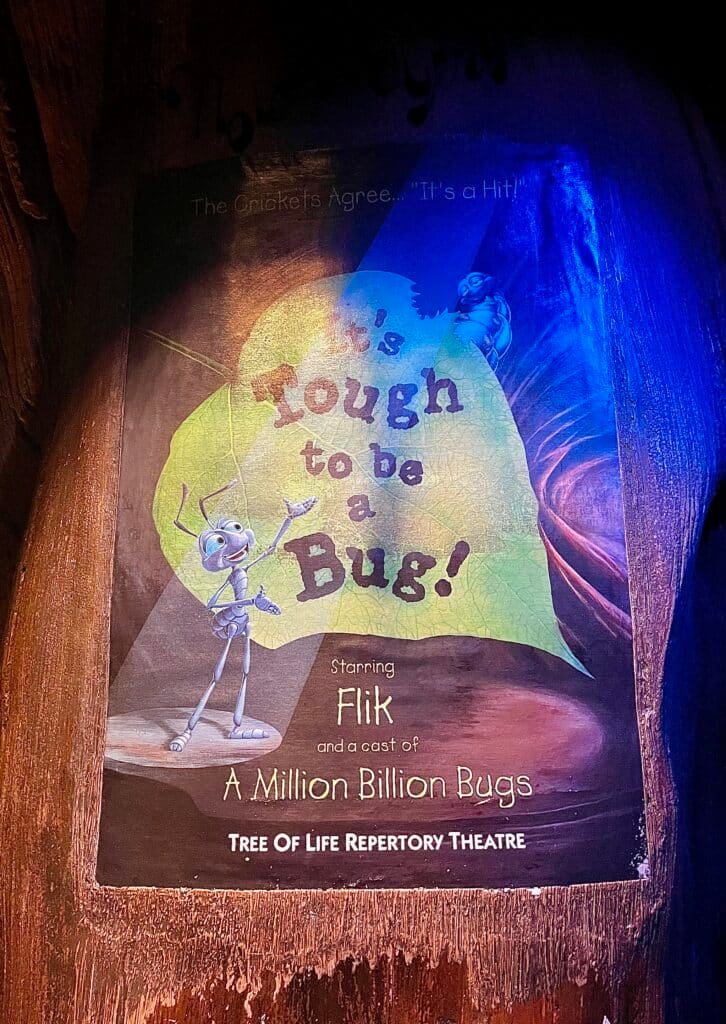 'It's Tough To Be A Bug' poster found inside the Tree of Life with just a spotlight illuminating Flik with the show title etched on a massive green leaf.