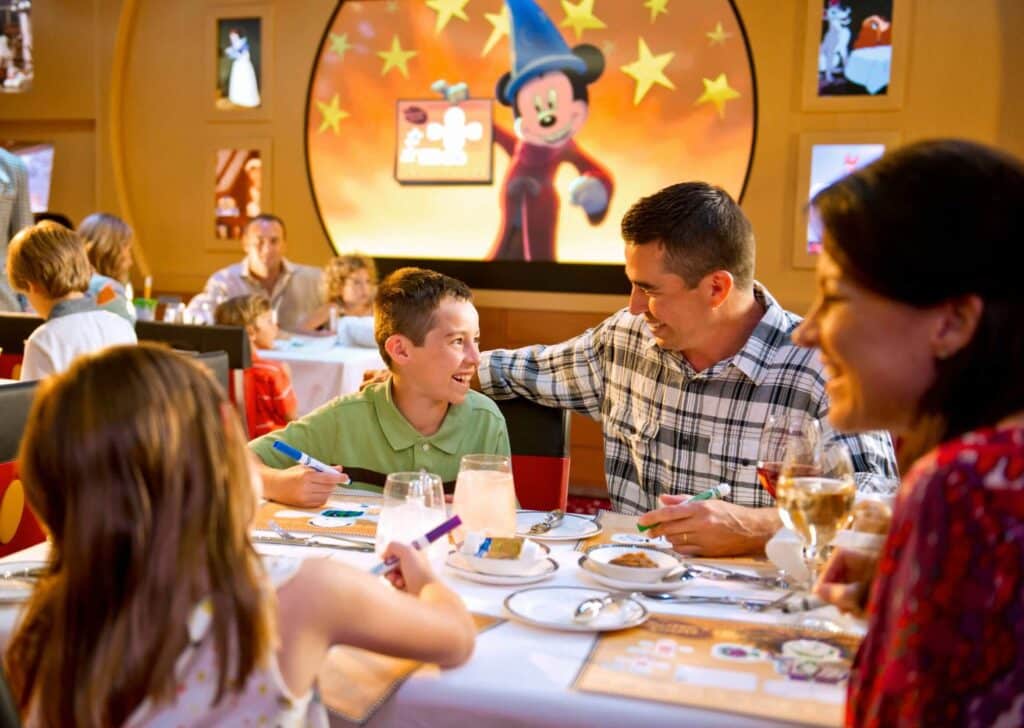 Family sharing a meal in a Disney restaurant with Mickey Mouse artwork