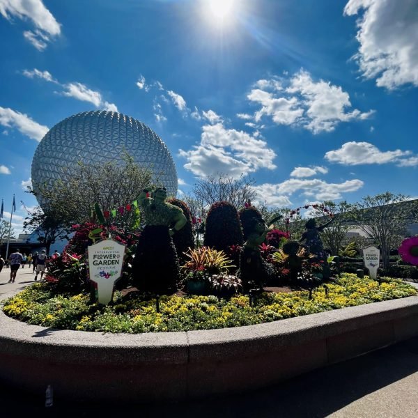 Encanto Topiary Entrance Display during EPCOT's International Flower and Garden Festival on a sunny day with the Space Ship Earth Icon in the Background